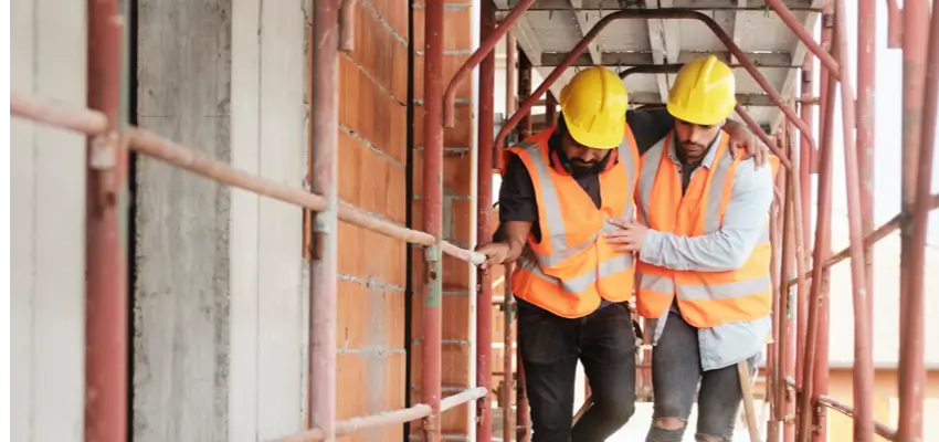 A man is helping an injjury man to walk through external construciton frame