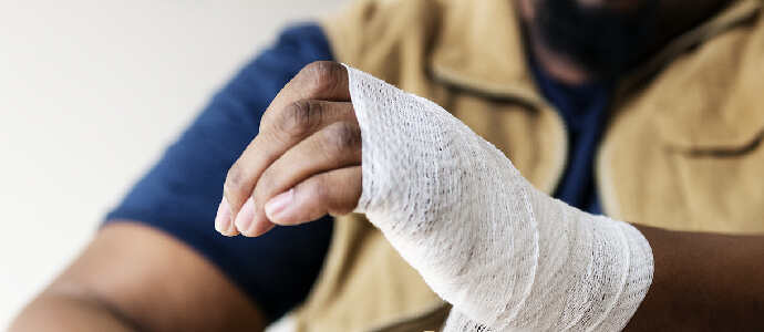 hand being bandaged in gauze wrap, personal injury