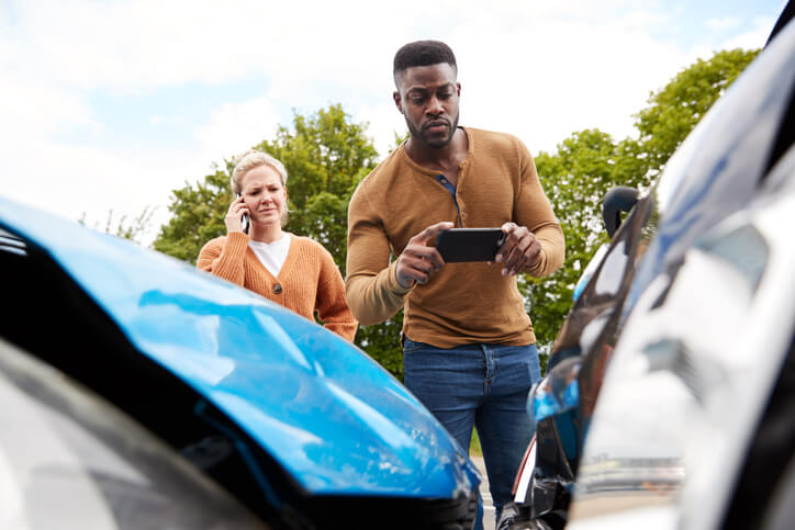 man taking picture of car accident