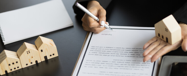 A woman signs a real estate contract