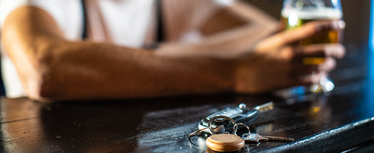 Man drinking a bar at the bar while placing his car keys on the table