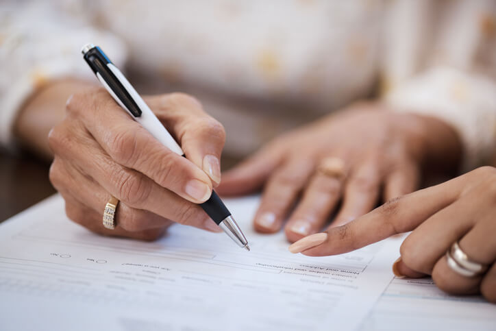 Older woman drafting her will with attorney