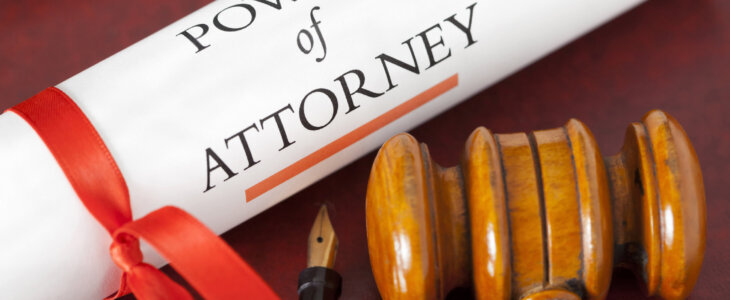 Power of Attorney legal document with a judges gavel, red ribbon and fountain pen.